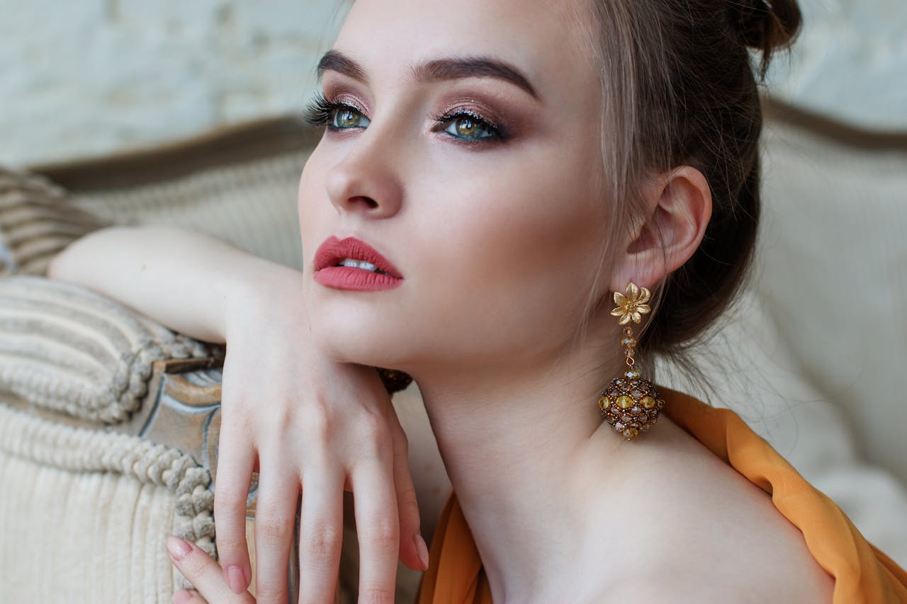 Stunning close-up portrait of a woman with elegant makeup and jewelry, epitomizing modern fashion and beauty.